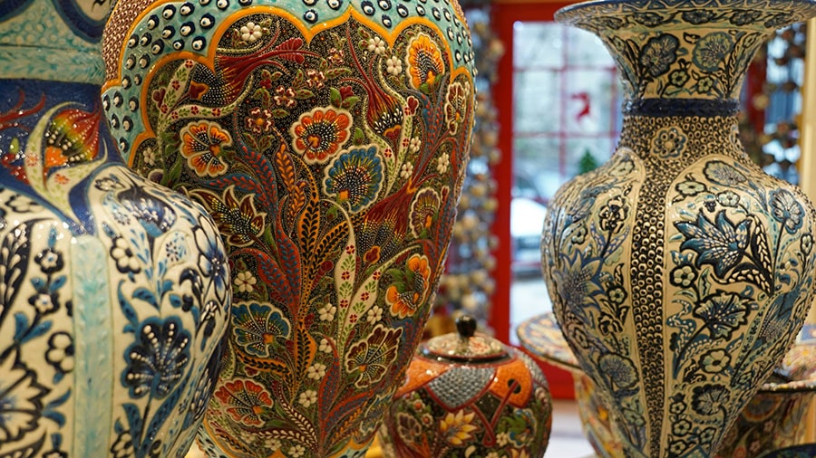 Persian handicrafts display including carpets, miniatures, and khatam work in Isfahan bazaar
